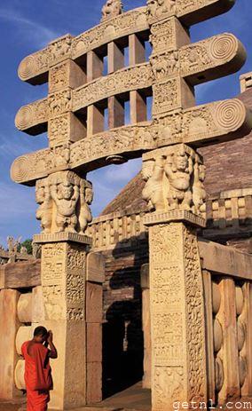 Worshiper at one of the gateways to the Great Stupa of Sanchi, India